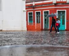 TRANSEUNTES SE PROTEGENDO DA CHUVA NO LARGO DA ORDEM