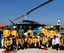 VOLUNTARIOS POSANDO FRENTE AO HELICOPTERO