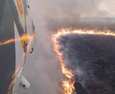 Foto de helicóptero sobrevoando incêndio