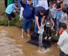 Foto de autoridades e crianças durante soltura de peixes