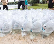 Foto de autoridades e crianças durante soltura de peixes