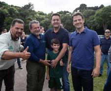 Foto de autoridades e crianças durante soltura de peixes