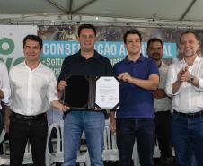 Foto de autoridades e crianças durante soltura de peixes