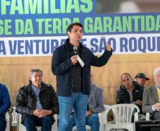 Foto de autoridades em evento de entrega dos títulos de regularização