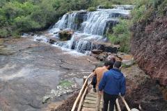 Visitantes passando por uma cachoeira