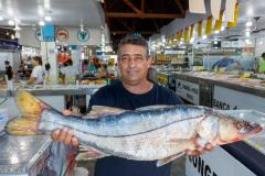 Comerciante com um peixe nas mãos