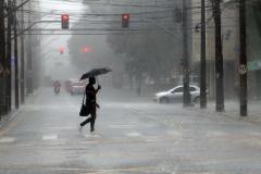 INDIVÍDUO EM MEIO A CHUVA TORRENCIAL NO MEIO DA RUA EM CURITIBA