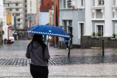 TRANSEUNTE SE PROTEGENDO DA CHUVA NO LARGO DA ORDEM