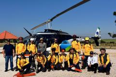 VOLUNTARIOS POSANDO FRENTE AO HELICOPTERO