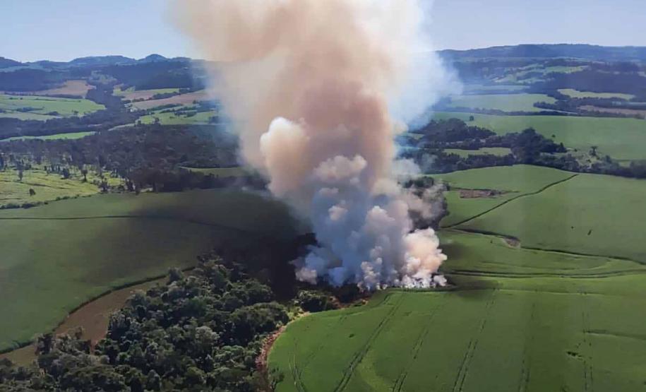 IMAGEM AÉREA MOSTRANDO ÁREA DE DESMATAMENTO COM INTENSA FUMAÇA