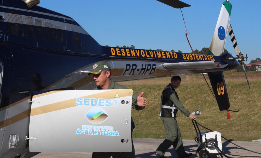 equipe PM e IAT próximos ao helicoptero pousado no chão