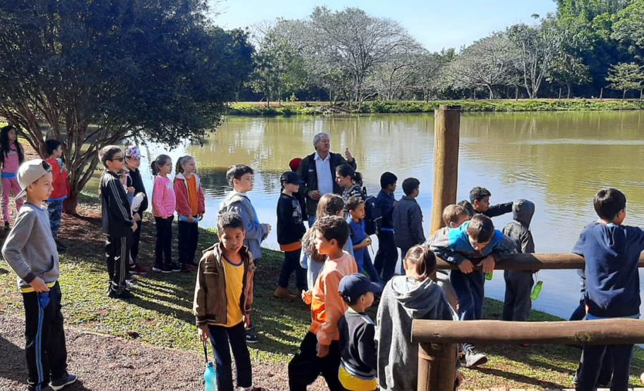 Crianças em aula ambiental em frente á lago