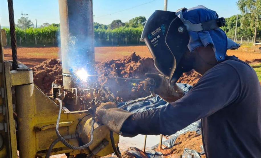 Operários perfurando poço