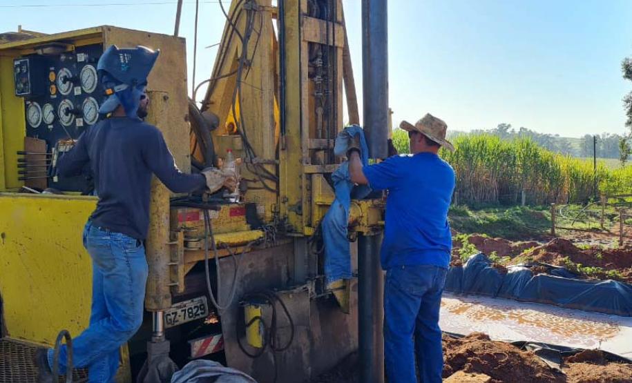 Operários perfurando poço