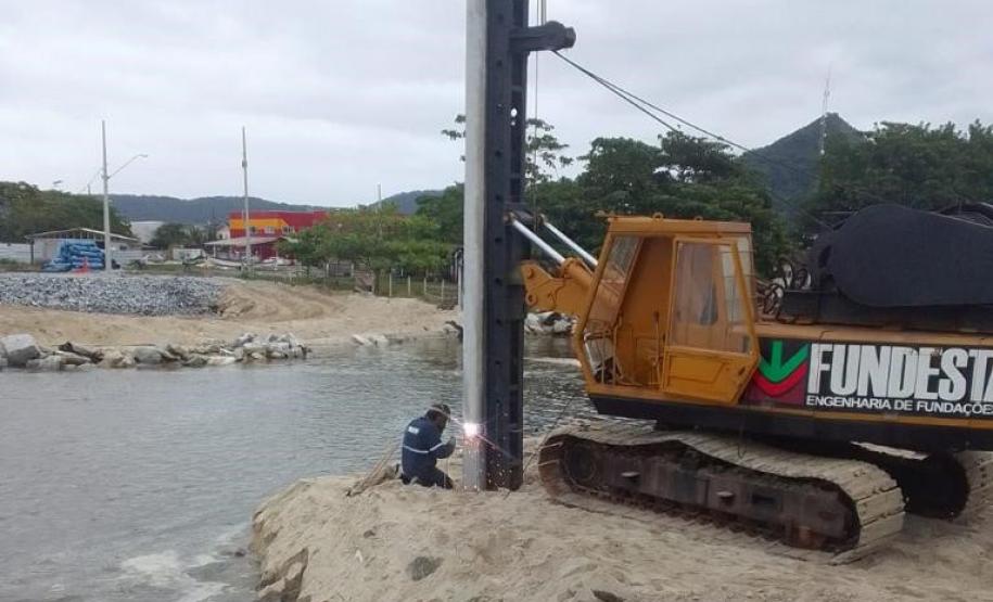 Trator e técnico do IAT fazendo a entalação de uma estaca na margem do Rio Matinhos