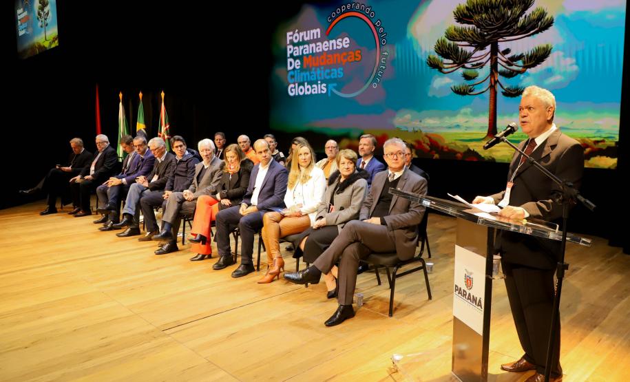 Apresentação fórum Paranaense de Mudanças Climáticas com membros assentados e apresentador discursando