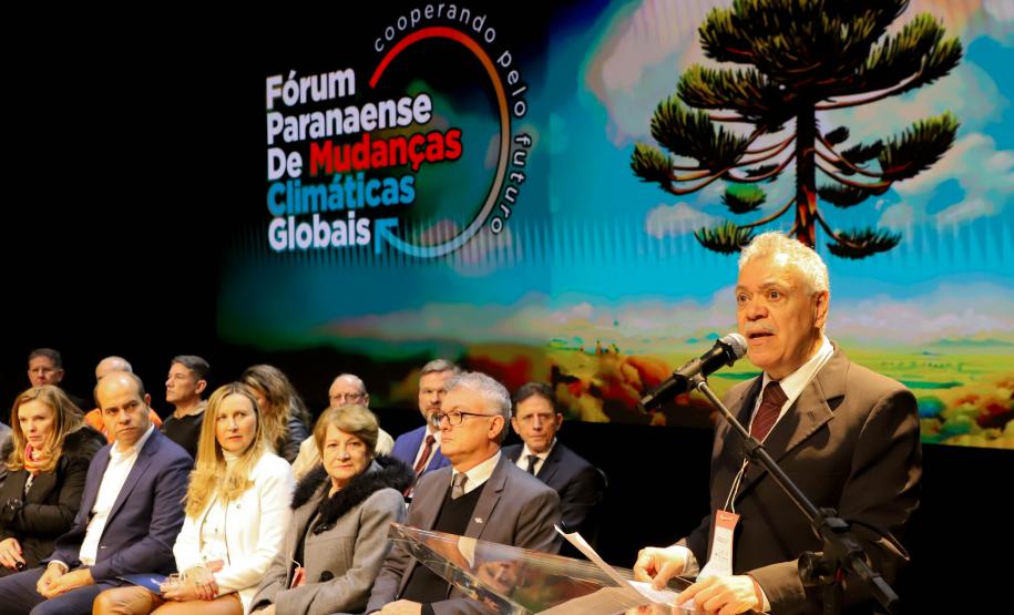 Apresentação fórum Paranaense de Mudanças Climáticas com membros assentados e apresentador discursando