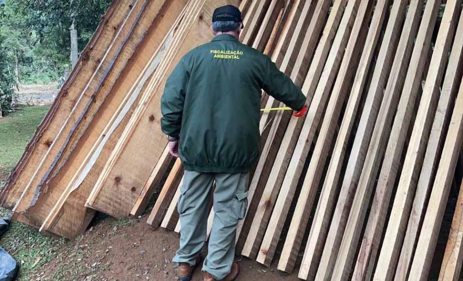 Foto de agente em frente a vigas de madeira