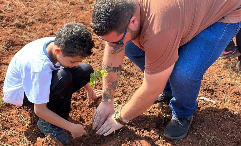 Servidor do IAT ensinando uma criança a plantar uma muda