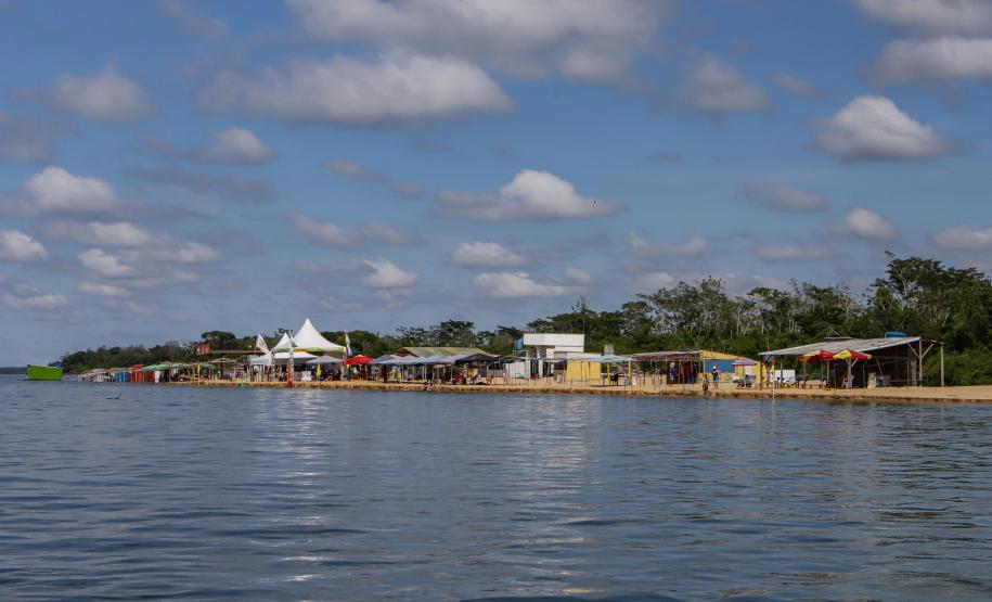 Margem do Rio Paraná com barracas próximas ao rio.