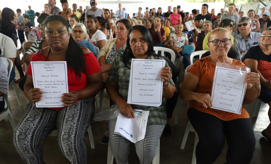 Beneficiárias posando para foto com o título de regularização em mãos