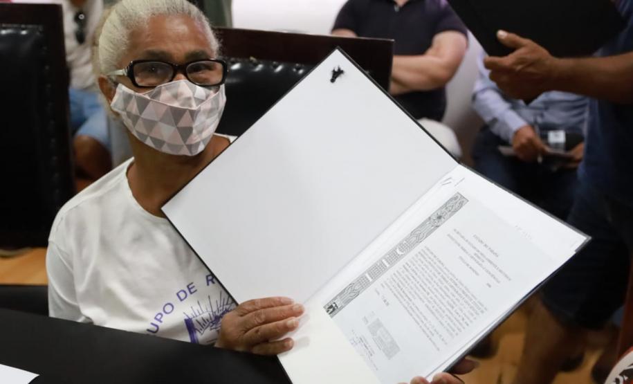 Beneficiária com o título de regularização em mãos.
