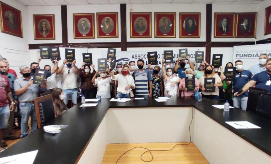 Beneficiários posando para a foto em evento de entrega dos títulos.