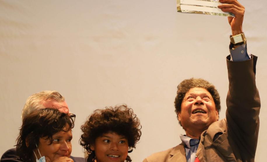 Beneficiária comemorando a aquisição do título de regularização.