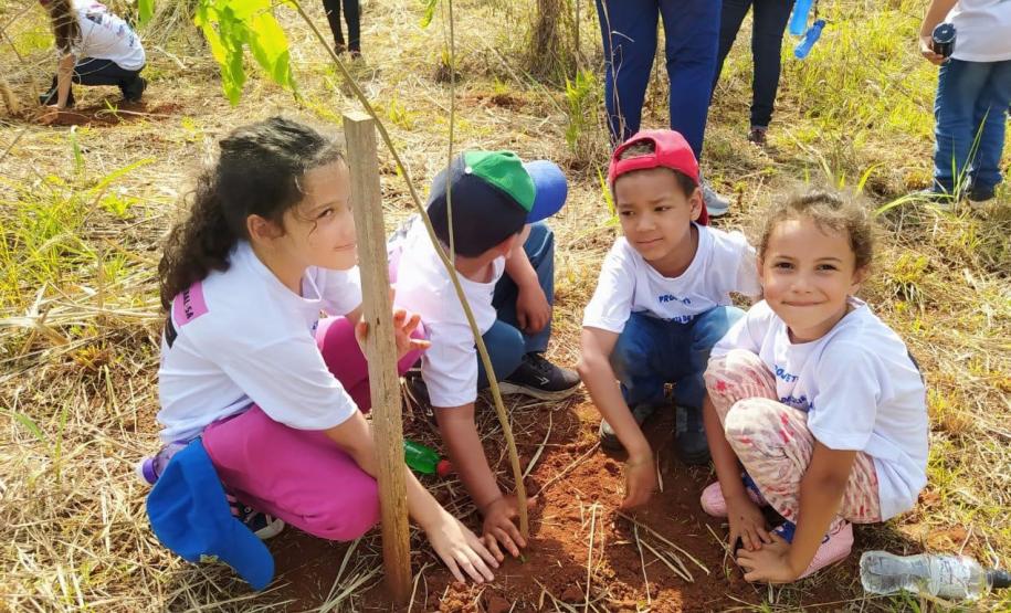 Grupo de quatro crianças plantando mudas