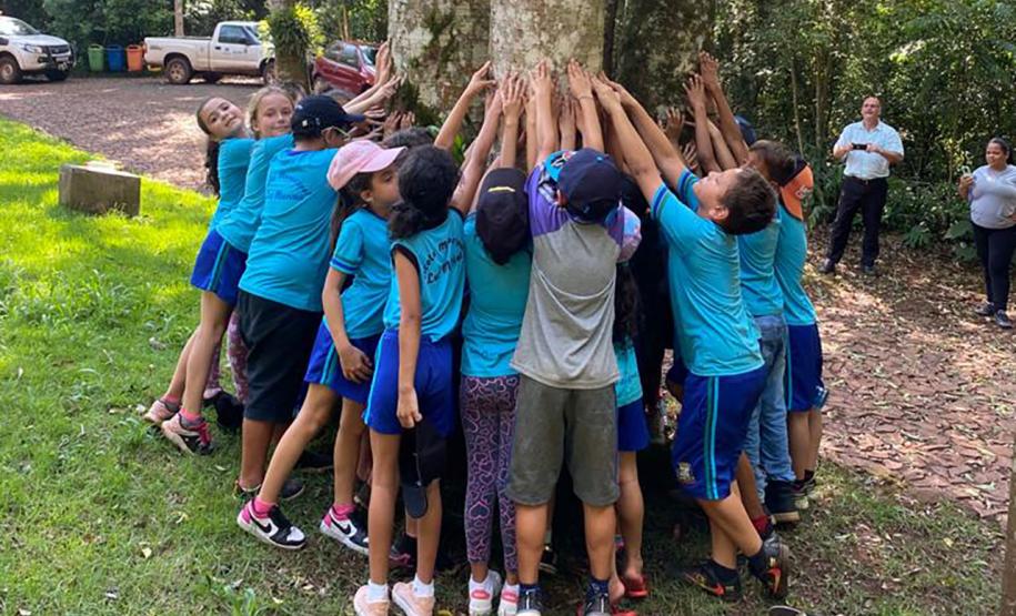 Crianças abraçando uma árvore
