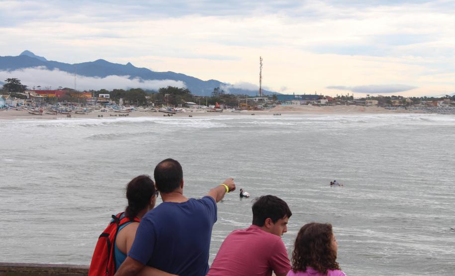 Família prestigiando um surfista surfando