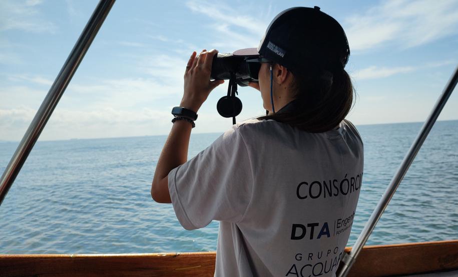Agente do consórcio observando o mar com binóculos