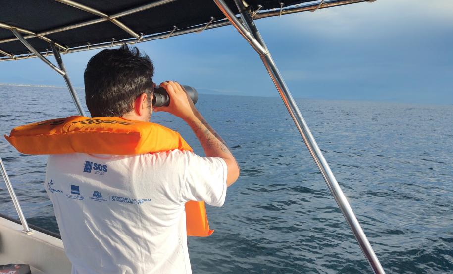 Agente do consórcio observando o mar com binóculos