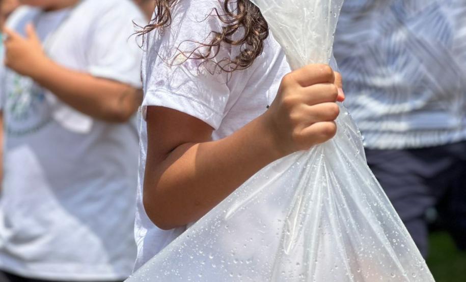 Criança com sacola com água transportando os peixes a serem soltos