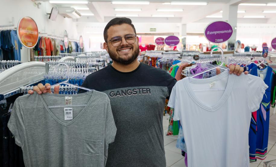 Comerciante com blusas nas mãos