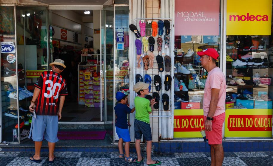 Clientes passando em frente ao comércio local
