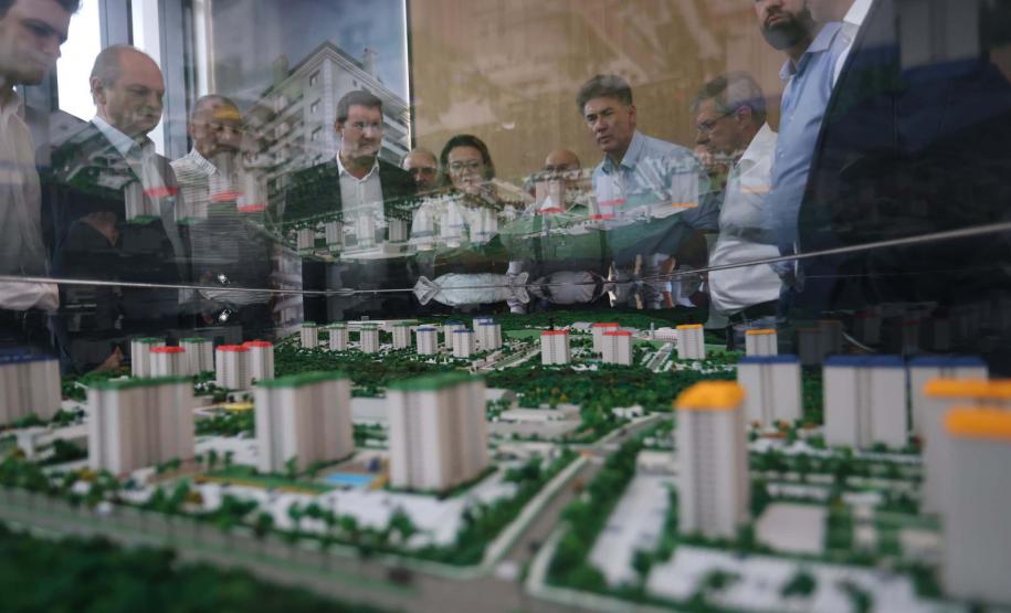 Foto de governador e equipe observando maquete
