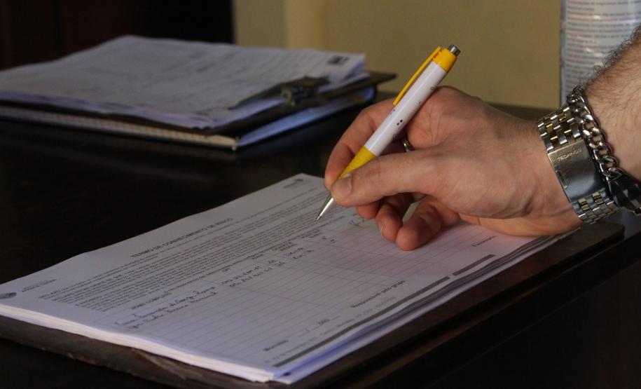 MÃO ASSINANDO DOCUMENTO