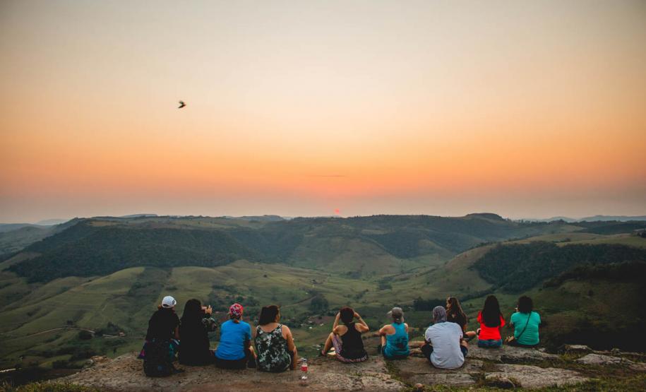 Foto de pessoas vendo o nascer do sol em montanha