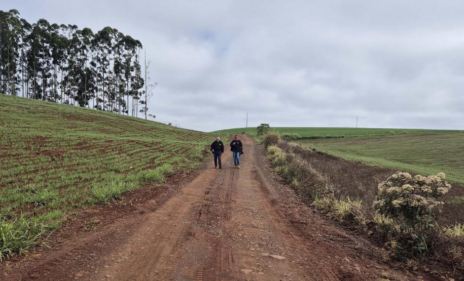 ESTRADA DE TERRA COM DOIS FISCAIS AO FUNDO
