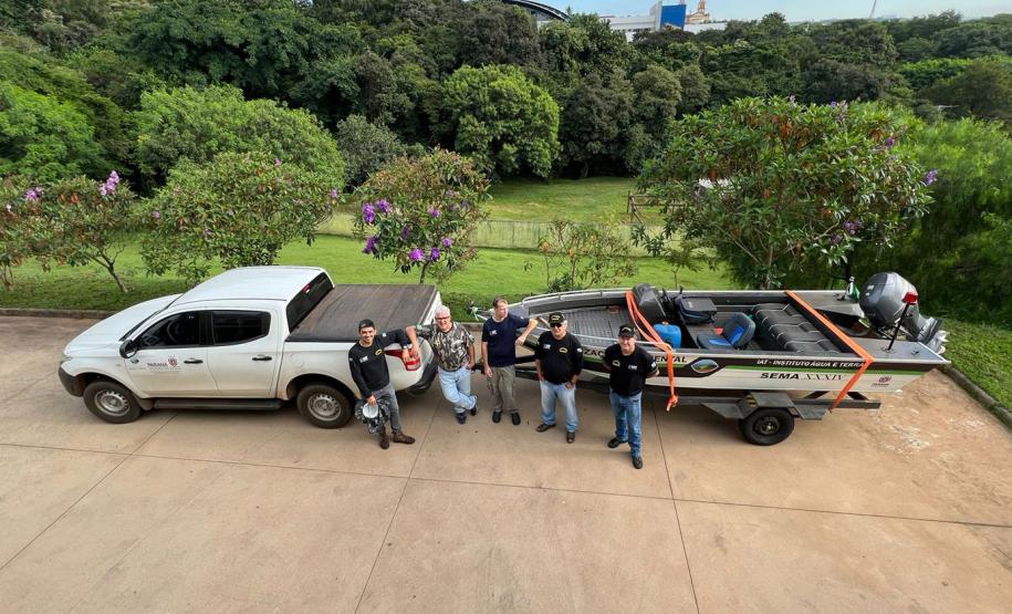 SERVIDORES POSANDO PARA FOTO A FRENTE DE VEÍCULO AUTO E HIDRO MOTOR