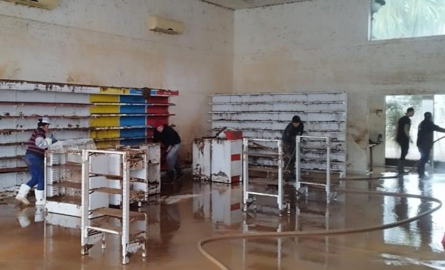 VOLUNTÁRIO EM AÇÃO LIMPANDO ESTABELECIMENTO ALAGADO