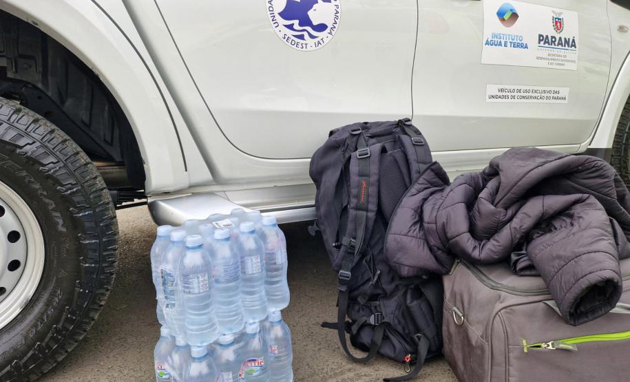 CAMINHONETA DO IAT AO LADO DE UM ENGRADADO DE GARRAFAS DE ÁGUA