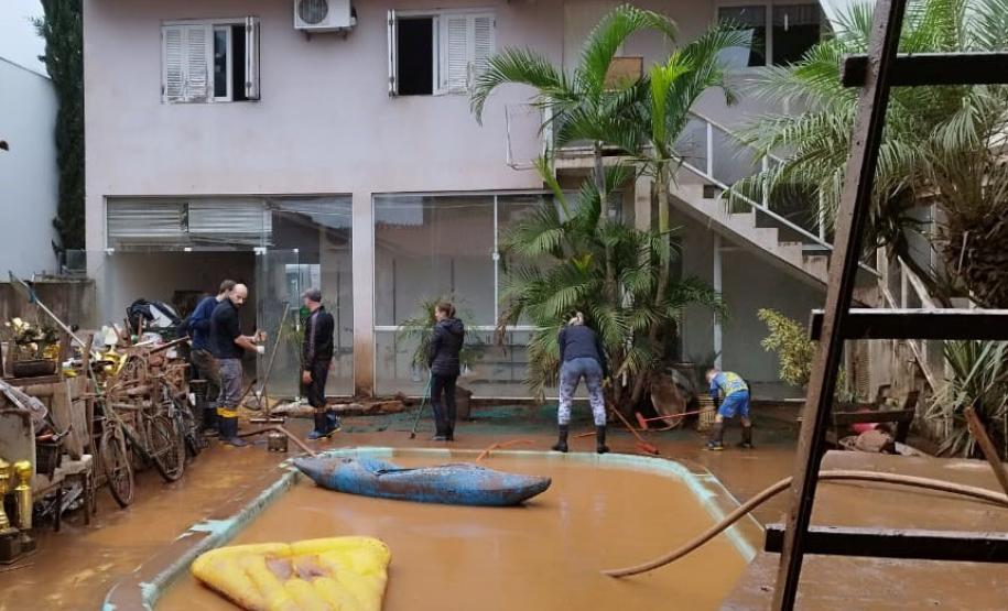 VOLUNTÁRIO EM AÇÃO LIMPANDO ESTABELECIMENTO ALAGADO