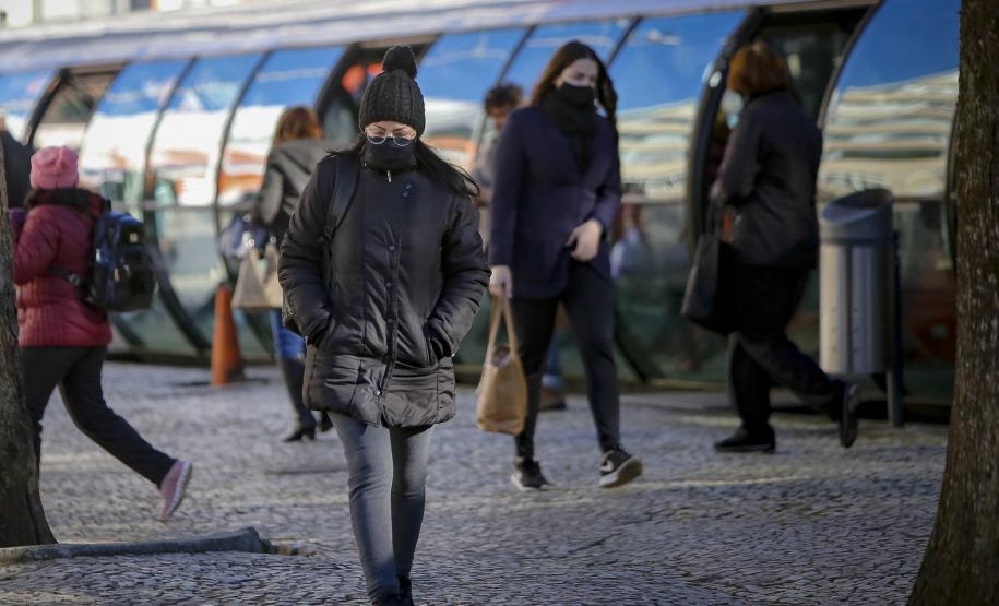 TRANSEUNTE ANDANDO FRENTE A UMA ESTAÇÃO TUBO NO INVERNO