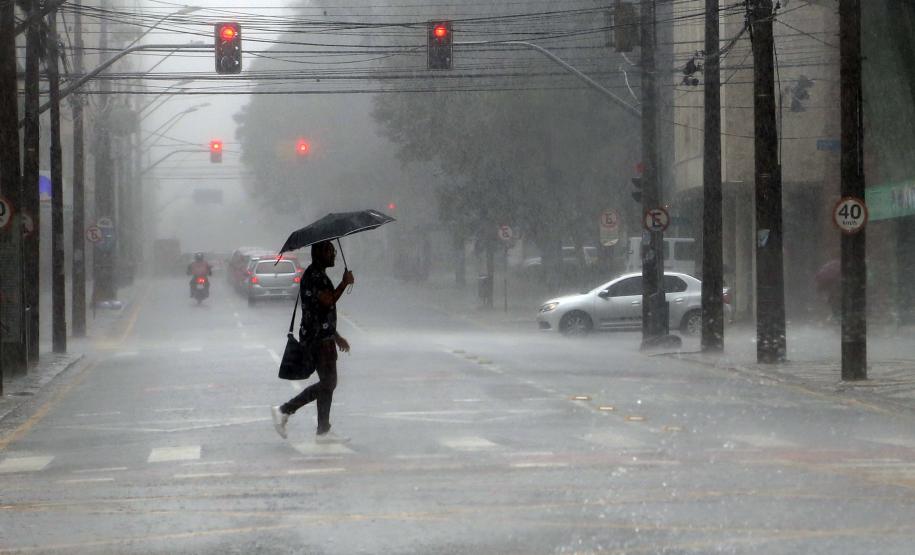 INDIVÍDUO EM MEIO A CHUVA TORRENCIAL NO MEIO DA RUA EM CURITIBA