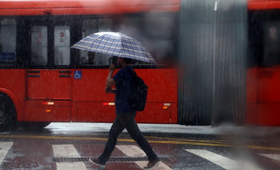 INDIVÍDUO EM MEIO A CHUVA TORRENCIAL NO MEIO DA RUA EM CURITIBA
