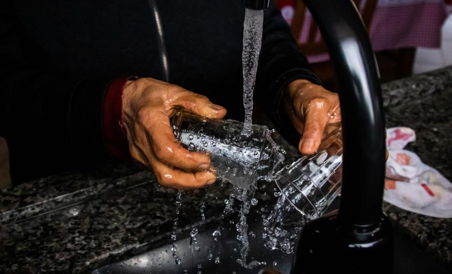 Foto de beneficiada por poço lavando louça