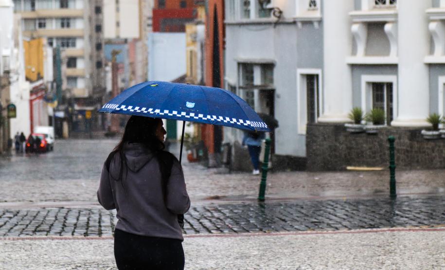 TRANSEUNTE SE PROTEGENDO DA CHUVA NO LARGO DA ORDEM