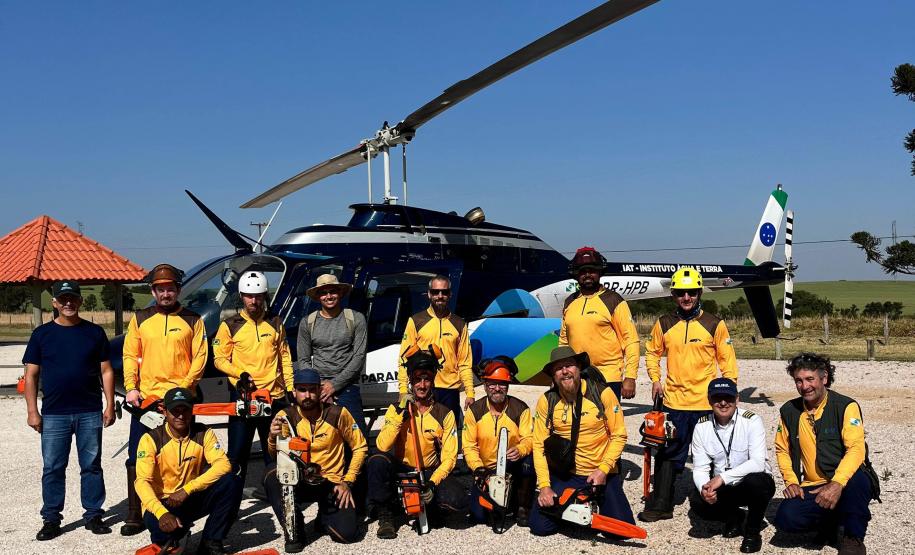 VOLUNTARIOS POSANDO FRENTE AO HELICOPTERO